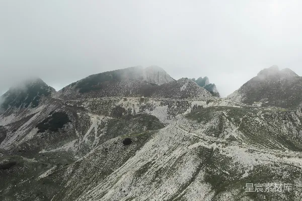高清摄影 一座非常高大的山，山中有一条路穿过。