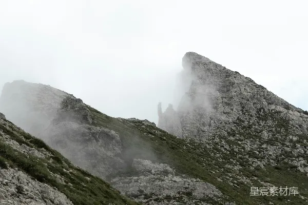高清摄影 在阴云密布的天气里，一座高耸入云、笼罩在雾气中的高山