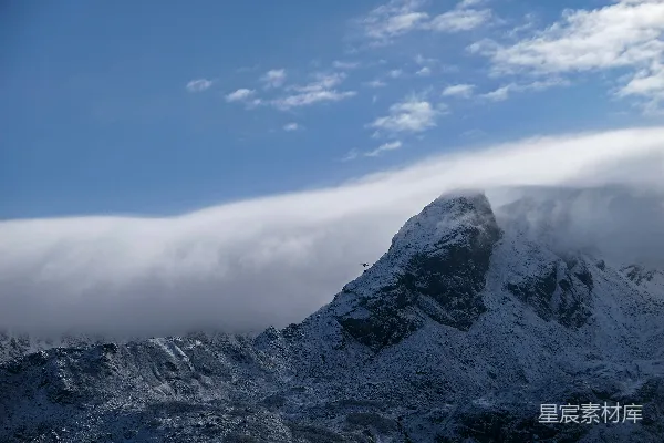 高清摄影 覆盖着积雪的山峰在云层密布的天空下