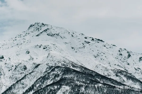 高清摄影 云层密布的天空下覆盖着积雪的山峰