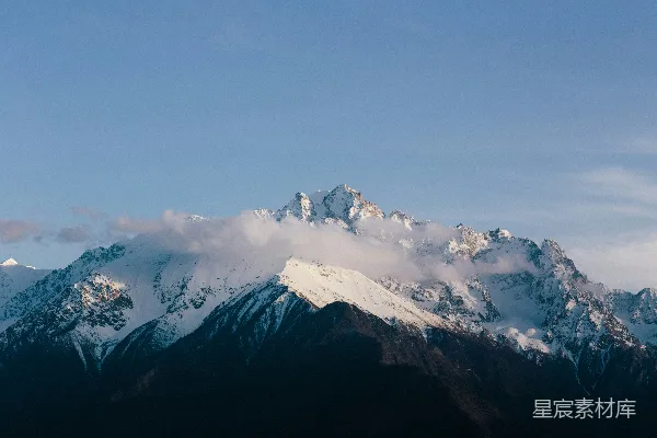 高清摄影 一座被白雪覆盖的大山，在蓝色的天空下。