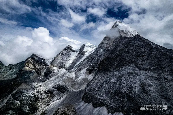 高清摄影 一座高耸入云的雪山，在多云的天空下