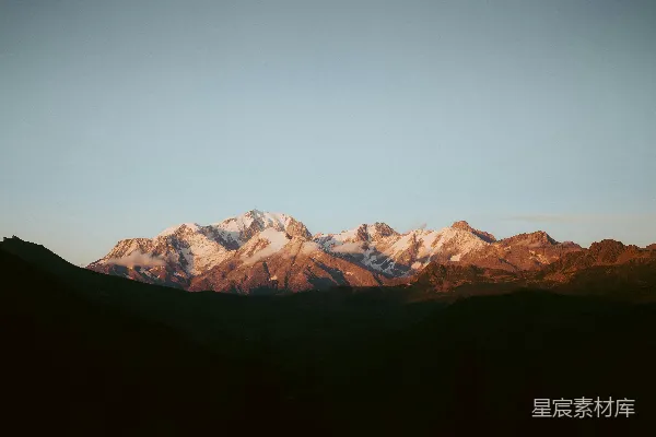 高清摄影 夕阳下的雪山被金色阳光照亮。