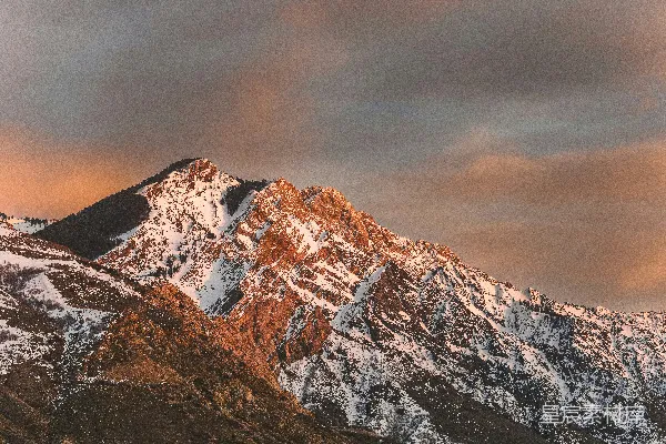 高清摄影 覆盖着积雪的山峰在阴云密布的天空下