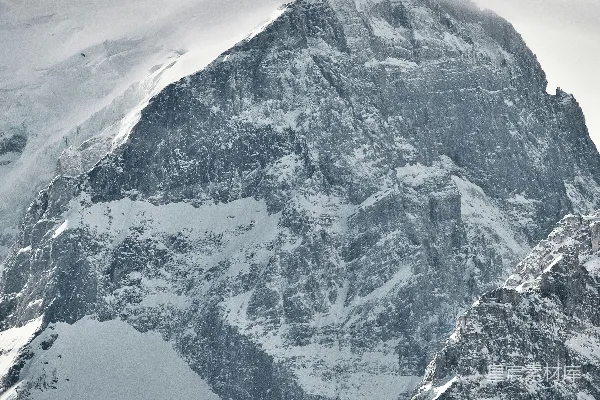 高清摄影 一座被积雪覆盖的大山在阴云密布的天空下
