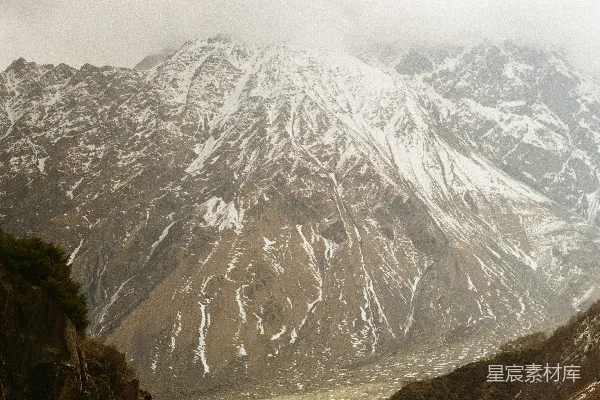 高清摄影 云层低垂，雪山在远处矗立。