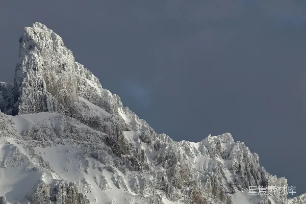高清摄影 被白雪覆盖的崎岖山峰在黑暗的天空下
