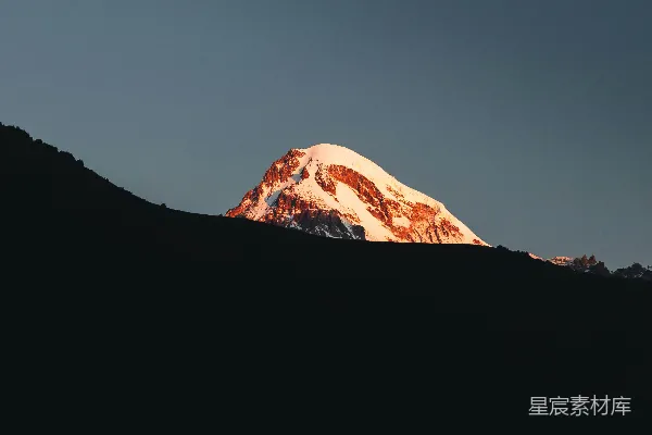 高清摄影 金光照射下的白雪覆盖的山峰。