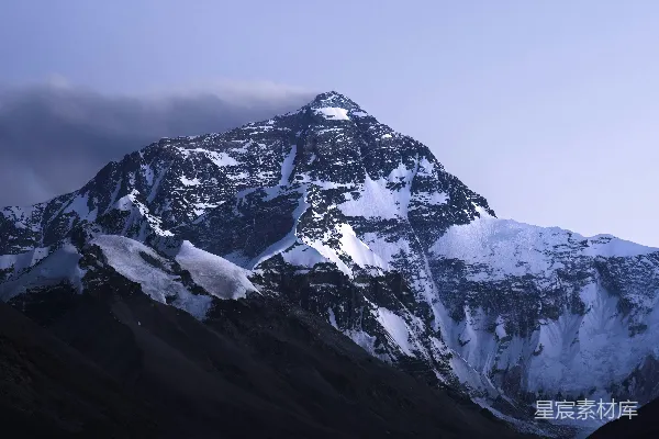 高清摄影 被雪覆盖的山峰，天空中有云层。