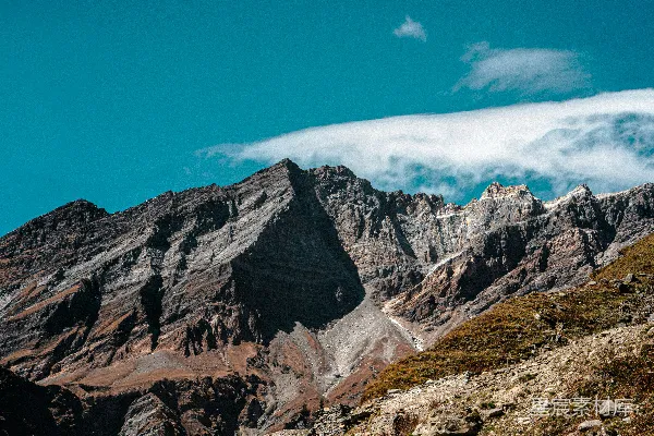 高清摄影 一座非常高大的山，天空中有几朵云。