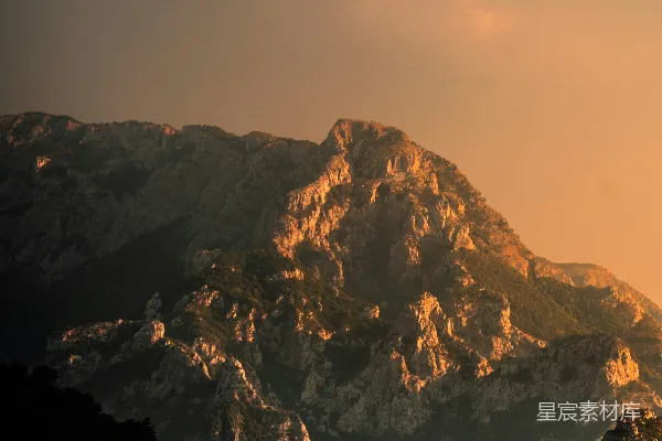 高清摄影 夕阳的金光照射在傍晚崎岖的山峰上。