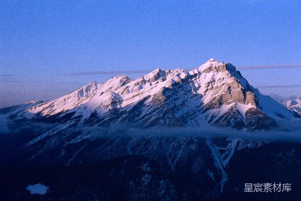高清摄影 白雪覆盖的山峰在晴朗的蓝天之下。