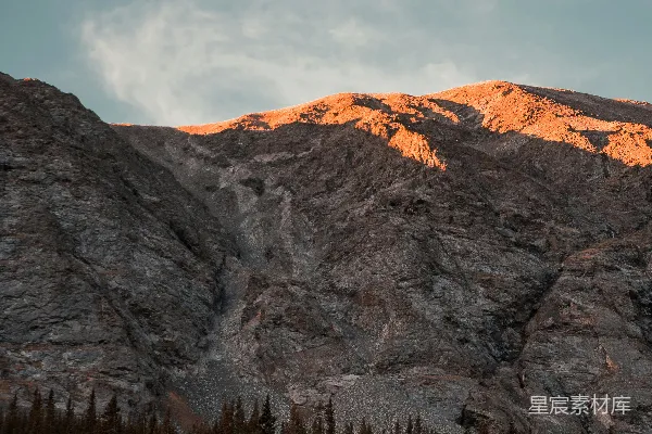 高清摄影 一座山峦上有树木，背景是天空。