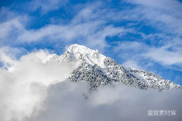 高清摄影 一座被雪和云覆盖的山在蓝天之下