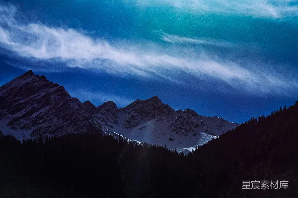 高清摄影 一座山峦连绵的景观，前景中有树木。