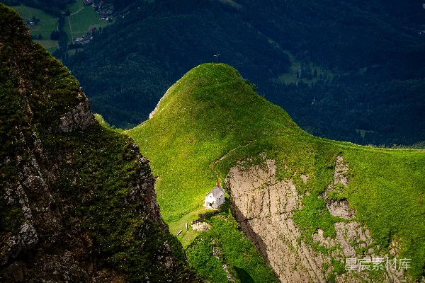高清摄影 一座绿山，山顶上有一座白房子。