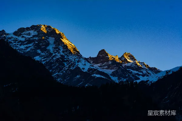 高清摄影 一座被雪覆盖的山，背景是蓝天。