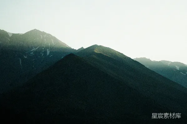 高清摄影 黑暗的山峰剪影映衬在明亮的天空下。