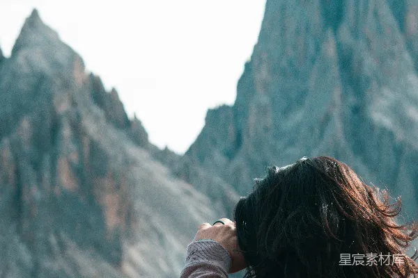 高清摄影 一个女人站在一座山前。