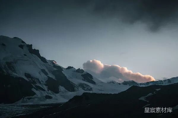 高清摄影 一座覆盖着积雪的山在阴云密布的天空下