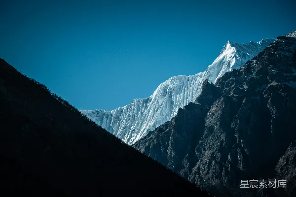 高清摄影 一座覆盖着白雪的山峰，背景是蓝天。