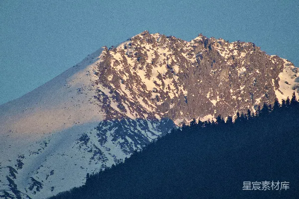 高清摄影 被金色的夕阳照亮的积雪覆盖的山峰。