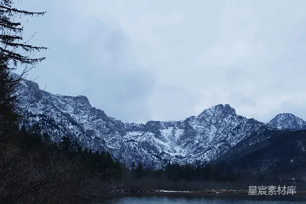 高清摄影 白天水边覆盖着积雪的山