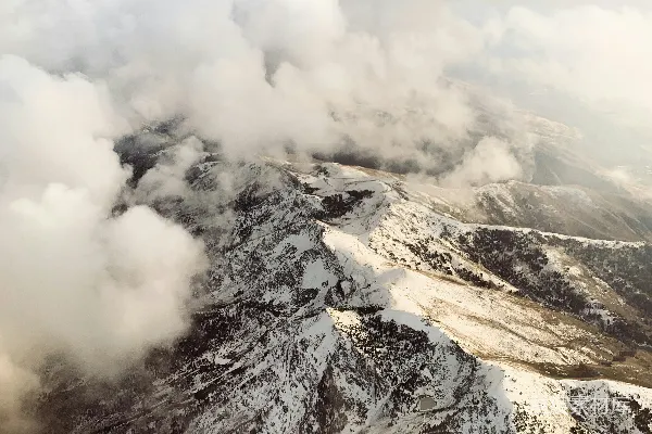 高清摄影 白雪覆盖的山峰上飘着白云