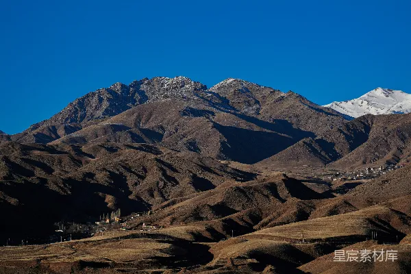 高清摄影 一座山脉，背景中是被白雪覆盖的山峰。