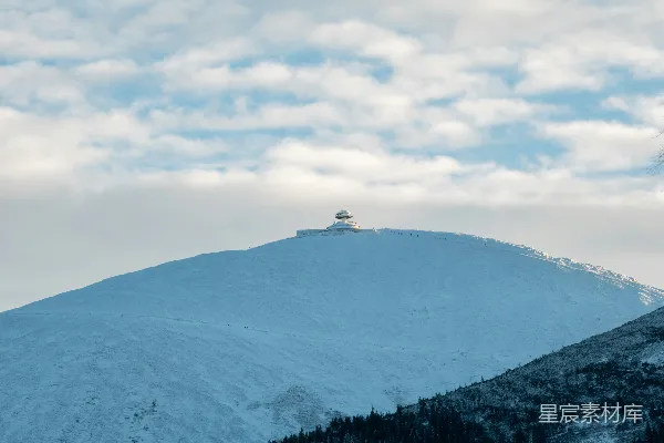 高清摄影 被白雪覆盖的山峰，在蓝云下的天空中