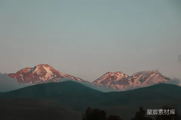 高清摄影 日出时分，雪山被金色的光芒照亮。