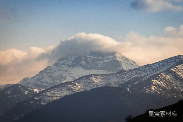 高清摄影 覆盖着积雪的山峰在阴云密布的天空下