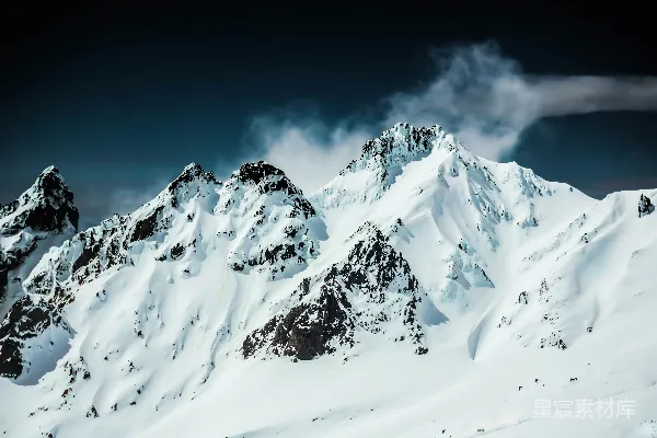 高清摄影 覆盖着积雪的山峰在阴云密布的天空下