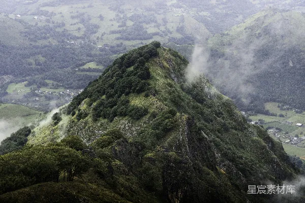 高清摄影 一座山，山上有树木，山下是一片山谷。