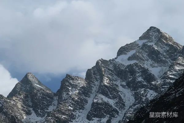 高清摄影 云层密布的天空下，覆盖着积雪的山峰