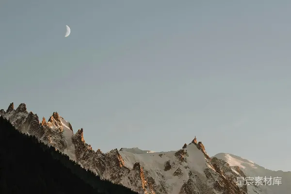 高清摄影 一座山的景色，天空中挂着一轮半圆的月亮。
