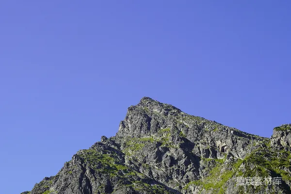 高清摄影 一座雄伟的岩石山峰在晴朗的蓝天之下。
