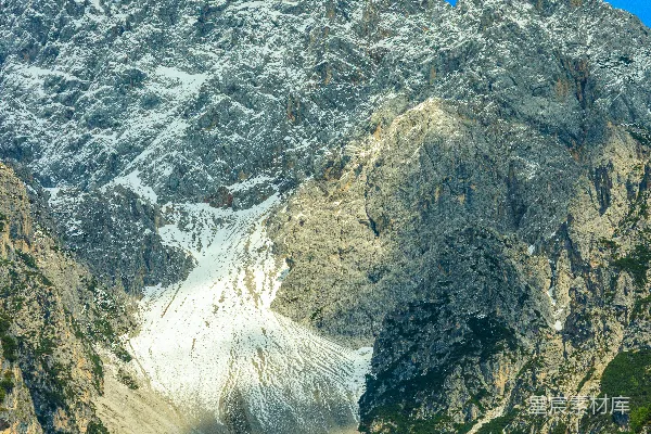 高清摄影 巍峨的雪山在蓝天白云下，山脚下是绿意盎然的山坡。