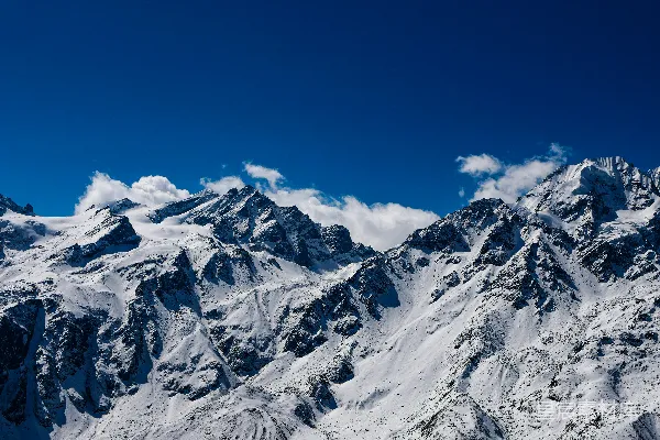 高清摄影 一座被雪覆盖的山脉在蓝天之下。