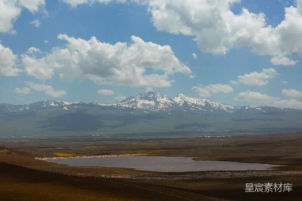 高清摄影 一座山脉的远景，前景中有一片湖泊。
