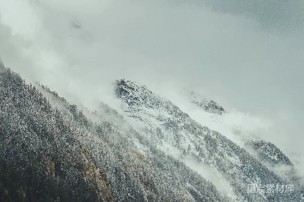 高清摄影 一座覆盖着积雪的山在阴云密布的天空下
