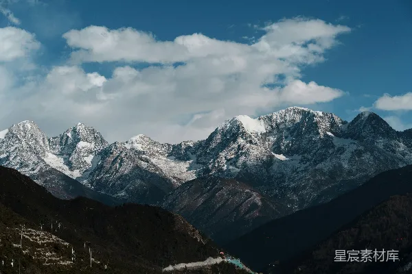 高清摄影 云层下的蓝色天空中的积雪覆盖的山脉