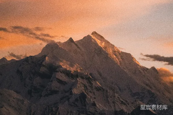 高清摄影 被美丽的橙色日落照亮的雪山峰顶。