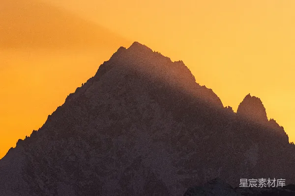 高清摄影 白雪覆盖的山峰在橙色的夕阳下显得格外壮丽。