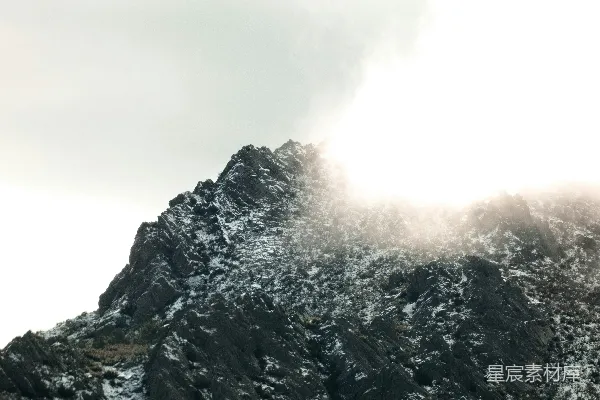 高清摄影 雪山顶峰部分被明亮的云层遮挡。