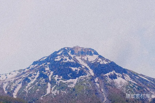 高清摄影 一座雄伟的山峰，白雪皑皑，绿树环绕。