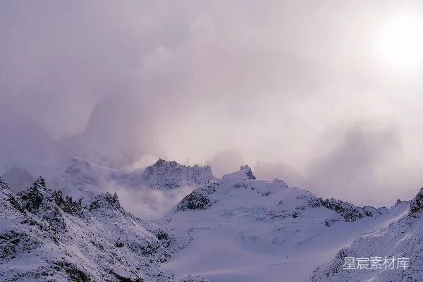 高清摄影 一座被雪覆盖的山在多云的天空下