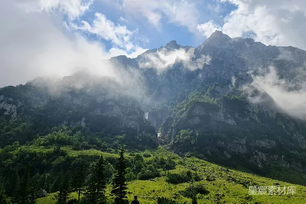 高清摄影 白天，山间绿树在白云下。