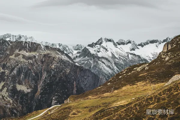 高清摄影 雪山耸立在草地上方。