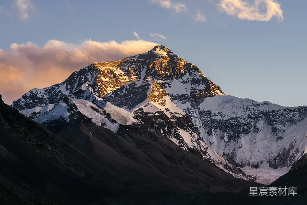 高清摄影 被雪覆盖的山峰，天空中有云。